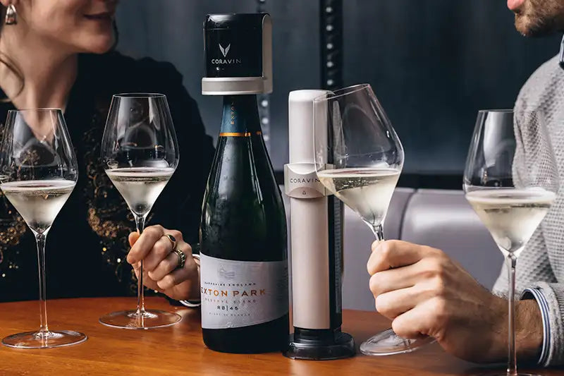Two people enjoying sparkling wine with a Coravin wine preservation system and a bottle of Braxton Park sparkling wine.